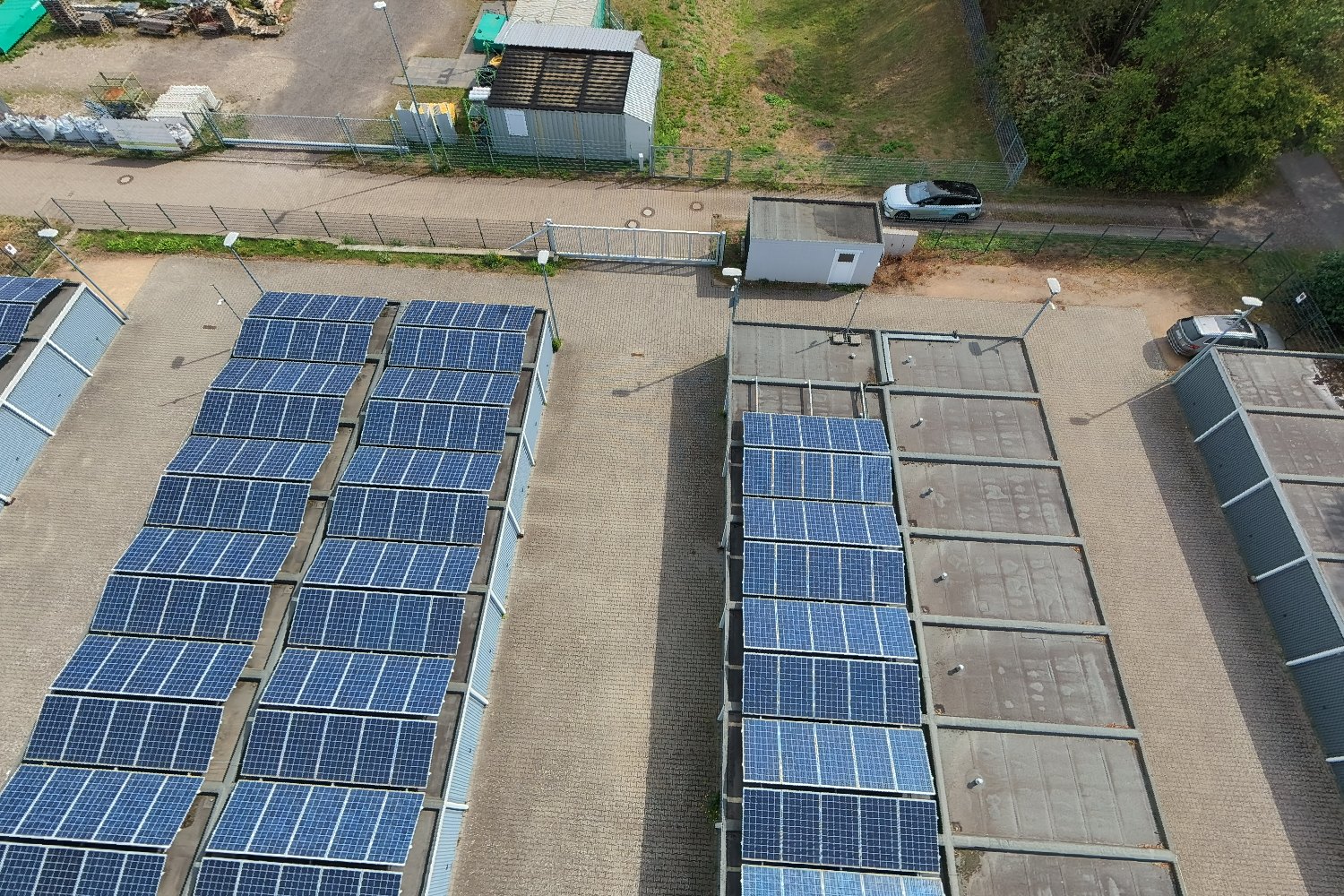 Schräge Luftaufnahme der Garagendächer mit Photovoltaik-Modulen und dem Technikhaus am Tor